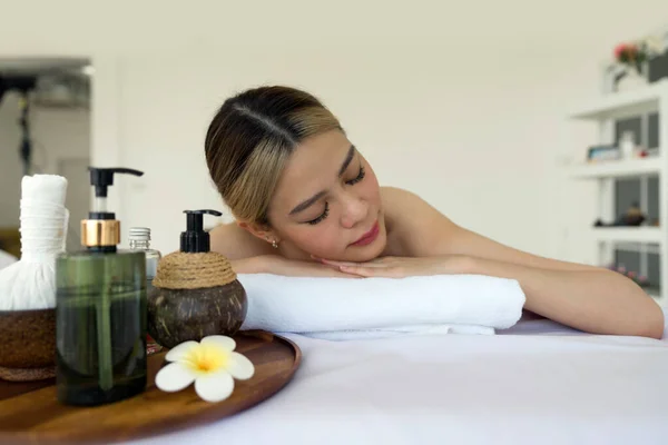 Holistic luxury wellness experience. A serene woman reclining leisurely within a soothing spa ambiance, surrounded by elements promoting tranquility.