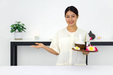 Serene spa seti, zarif bir şekilde elinde canlı çiçeklerle dolu bir tepsi tutan bir kadın.