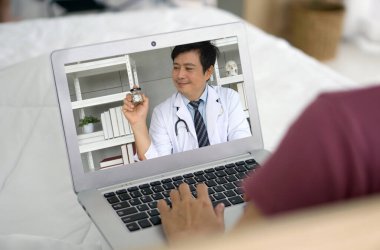 Hekimlerin bilgisayarındaki izleyici videolarını dikkatlice izleyen bir kadın..