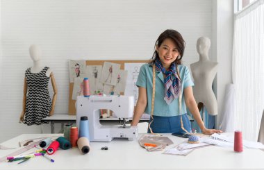 Kendini bir dikiş makinesi üzerinde tutkuyla çalışan bir kadın, dikkatle yeni bir kıyafet hazırlıyor, kullandığı iplikler kadar sıkı bir konsantrasyon yarası var..