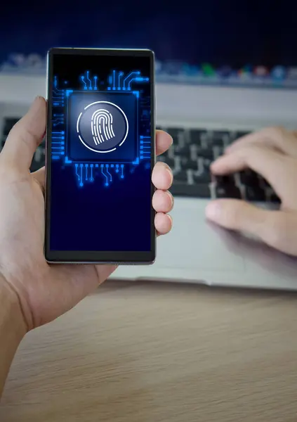 Futuristic digital processing of biometric identification fingerprint scanner on smartphone. Man using mobile phone and laptop computer.