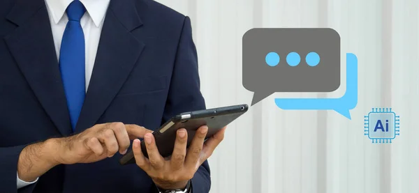 A man wearing a suit typing on tablet computer, live chat chatting with AI. Social network concepts, chatting conversation in chat box icons pop up. Ai technology