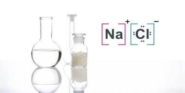 Flat Bottom Flask ve Volumetrik şişe içinde kristal berrak sıvı yanında moleküler yapı yeri olan Kimyasal Reaksiyonlu Şişede tuz.