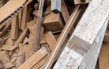 White wooden board lay on the leftover wooden pieces. Stacked together in a pile. Top view