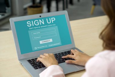 Back view of businesswoman in suit engrossed in creating her identity online, registering for an account on laptop computer. Digital Life Exploration