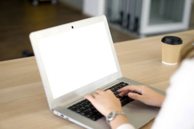 Back view of businesswoman sit at desk in office typing on laptop computer keyboard with white screen.