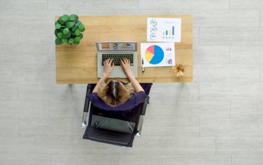 Modern bir iş yerinde dizüstü bilgisayarla veri analiz eden profesyonel bir kadın. Üst görünüm