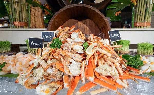 stock image Superbly cooked fresh seafood cold station at International Buffet Restaurant. Prawn, Crab and Scallop on ice decorated with wooden bucket