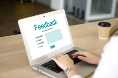 Bir bayan dizüstü bilgisayarında yazmakla meşgul, ekranında geri bildirim formu var..