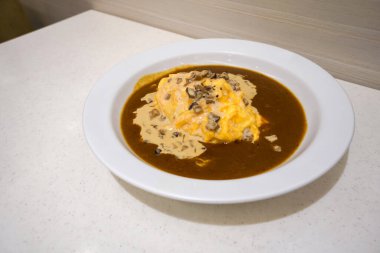 Kremalı Mantar Omleti Körisi. Beyaz seramik tabakta servis edilen körili pilav. Japon restoranında baharatlı yemekler..