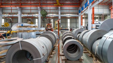 Endüstriyel bir ortam, endüstrideki organize kaosu yansıtan düzgün çelik levhalarla dolu..