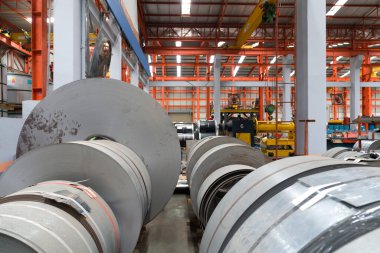 Endüstriyel bir ortam, endüstrideki organize kaosu yansıtan düzgün çelik levhalarla dolu..