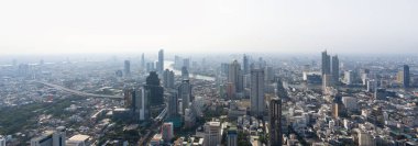 Gökdelen ve şehir binalarının karışımından oluşan hareketli bir şehrin panoramik görüntüsü. Hava kirliliği ile Bangkok gökyüzü 2,5