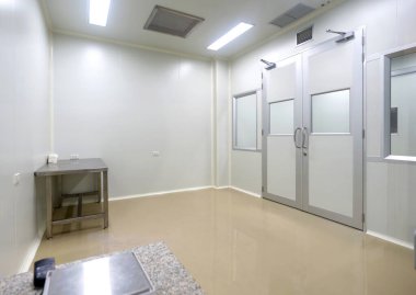 Laboratuvar aktiviteleri için kontrollü giriş kapısı ve minimal tasarımı olan temiz oda ortamı