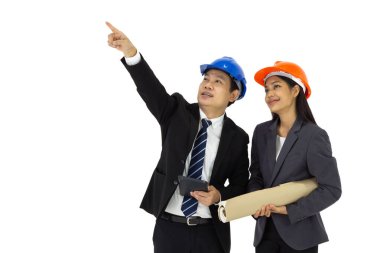 Proje sahibi ve yardımcısı yapım aşamasındaki projeyi kontrol etmek için koruyucu kask takıyorlar. İnşaat çizimi kadının elinde. Beyaz arkaplanda stüdyo ışığı olan bir portre.