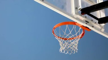 Bir basketbol topu potaya çarptı ve parlak mavi gökyüzüne doğru uçtu.