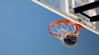 Parlak mavi gökyüzüne karşı bir dizi basketbol potası atışı. Video