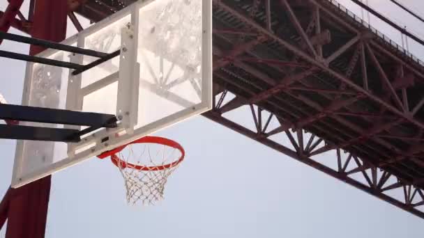 バスケットボールがフープを打ち 明るい青い空に向かって飛ぶ — ストック動画