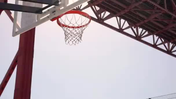 Ein Basketball Schlägt Den Korb Und Fliegt Gegen Einen Strahlend — Stockvideo
