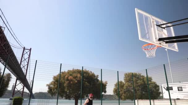 Muž Hodí Basketbal Koše Slunečného Dne Mostem Přes Řeku Pozadí — Stock video