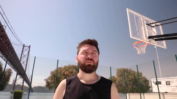 男はバスケットボールの裁判所に立って周りを見回す — ストック動画