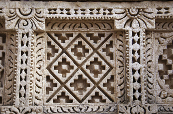 Carved Patola (Double Ikat) pattern on the inner wall of Rani ki vav, an intricately constructed stepwell on the banks of Saraswati River. Patan in Gujarat, India.