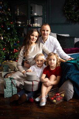 Genç anne, baba ve iki çocuk birlikte geçirdikleri kış tatillerini mutlu bir şekilde kutluyorlar.