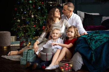 Mutlu aile babası, anne ve çocuklar Noel süslenmiş evde iyi vakit geçiriyorlar.