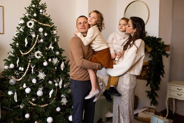 幸せな家族の父親 母親と子供の男の子と少女は クリスマスに飾られた家で楽しい時間を過ごします ストック画像