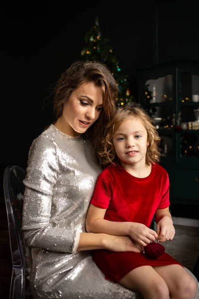 屋内でクリスマスツリーの近くで幸せな母と娘 ロイヤリティフリーのストック写真