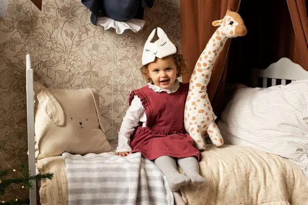子供の部屋で遊んでいる若い女の子 おもちゃの動物と自宅でベッドで ロイヤリティフリーのストック写真