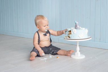 Çocuk ilk doğum gününde pastasını elleriyle eziyor yere oturuyor ve pasta partisini mahvediyor.