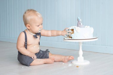 Dağınık bebek ilk doğum gününde pastasını elleriyle eziyor yere oturuyor, pasta partisini mahvediyor.