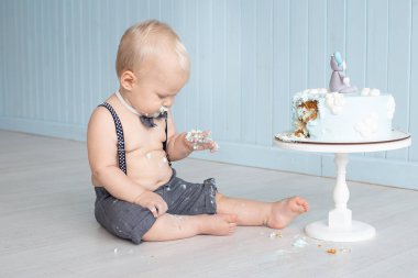 Küçük bebek ilk doğum gününde pastasını eliyle eziyor yere oturuyor, pasta partisini mahvediyor.