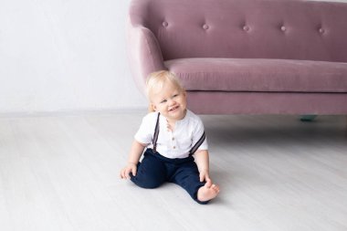 Küçük çocuk evde, kanepenin yanında Strabismus gözleri var. Aile ve çocukluk kavramı, tatil