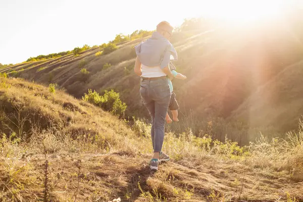Anne, küçük oğlunu doğada doğada büyüttü. Güneş ışınlarıyla çimlerin üzerinde, yeşil tepelerin yakınında oturuyordu.