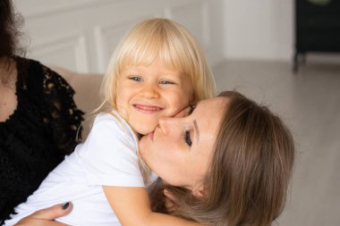 Gülümseyen mutlu anne ve küçük oğlu, Strabismus gözlü, şaşı gözlü çocuk. Mutlu gülen yüzler