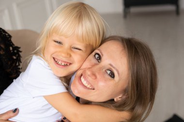 Gülümseyen mutlu anne ve küçük oğlu, Strabismus gözlü, şaşı gözlü çocuk. Mutlu gülen yüzler