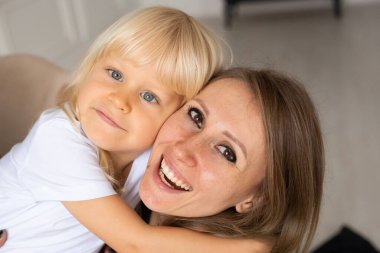 Mutlu anne ve küçük oğlunun evde portresi. Strabismus gözlü, şaşı gözlü çocuk. Mutlu gülen yüzler