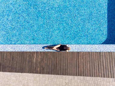 Güzel bir yaz geçmişi var. Oteldeki havuzda bir kadının hava aracı görüntüsü. Yaz tatili, yaz tatili..