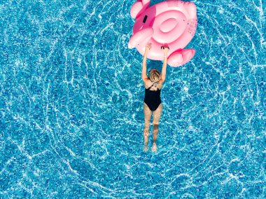 Flamingo havuzunda yüzen bir kadın, insansız hava aracı manzaralı. Yaz tatili