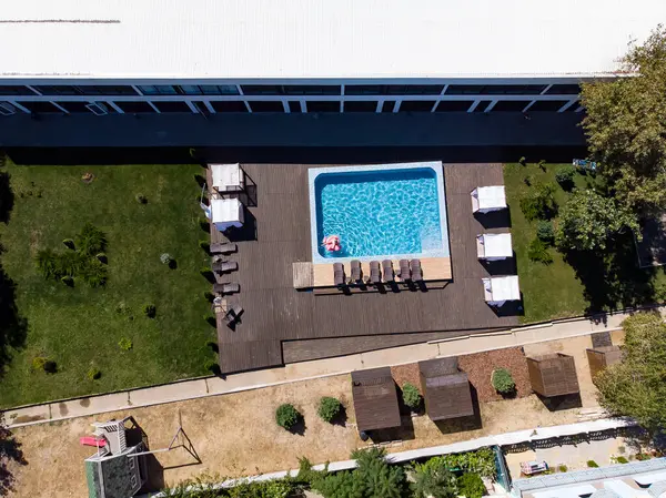 Havuzda yüzen flamingo yüzen kadın otelde havuzda yüzüyor. Yaz tatilleri, karantina sırasındaki yaz tatilleri. Hava aracı görünümü