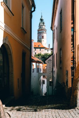 Cesky Krumlov 'da sıcak bir yaz günü. Bir ara sokak var ve sonunda kuleyi görebilirsiniz.