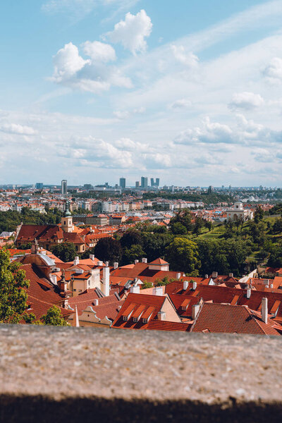 Prague's iconic cityscape with orange roofs and historic architecture from above.