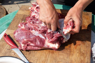 Erkek eller kesilir, et kesilir. Kasap geleneksel festivalde et hazırlar.