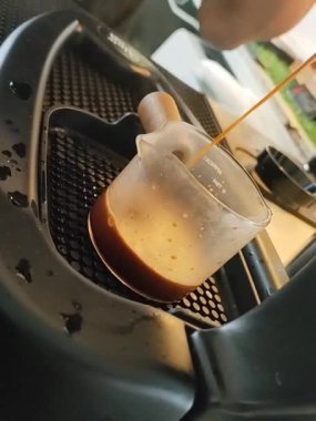 Kahve barmen tarafından yavaş yavaş elle demlenir, aromatik, sabah keyfine hazır. Bu video alışılmadık ve eğimli bir açıyla çekilmiş..
