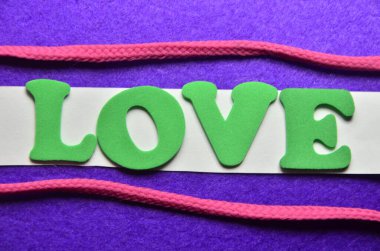 Aşk sözcüğü ahşap bir arka planda yer alır..