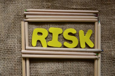 Tahta arka planda beyaz harflerle risk metni