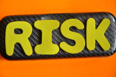 Siyah bir kağıt üzerinde metin ve turuncu arka planda sarı bir etiket.