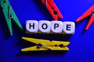 Umut ve yardım kavramı. Siyah arkaplanda tahta küplerle renkli harfler ve kelimeler..